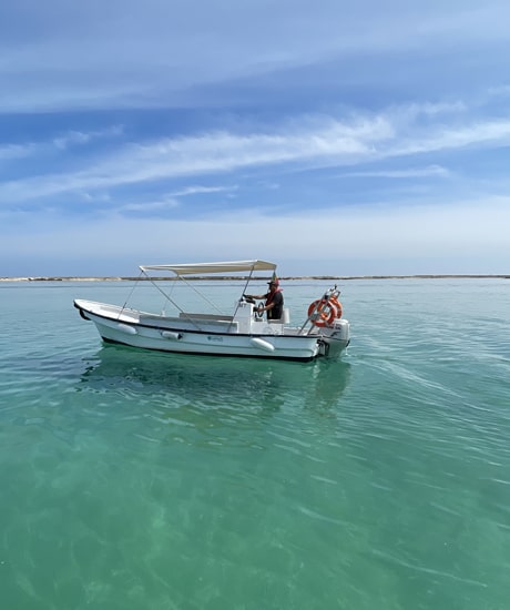 man driving a speedboat in the algarve sea